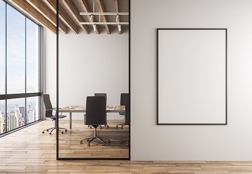 an empty conference room in an office building with a blank canvas on the wall